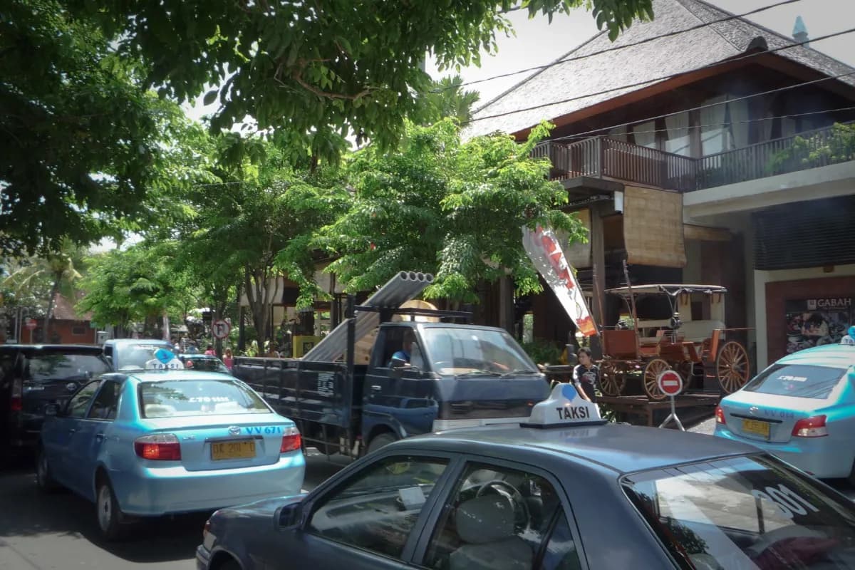 Several taxis on a busy Bali street, showing common transport options for travelers.