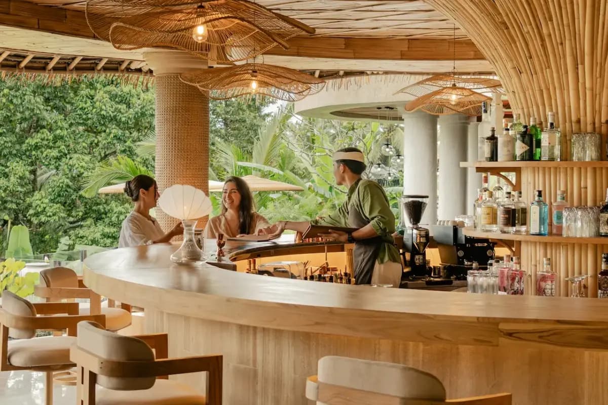 Guests enjoying drinks at an Ubud bar with a relaxed setting for cocktails and evening gatherings.