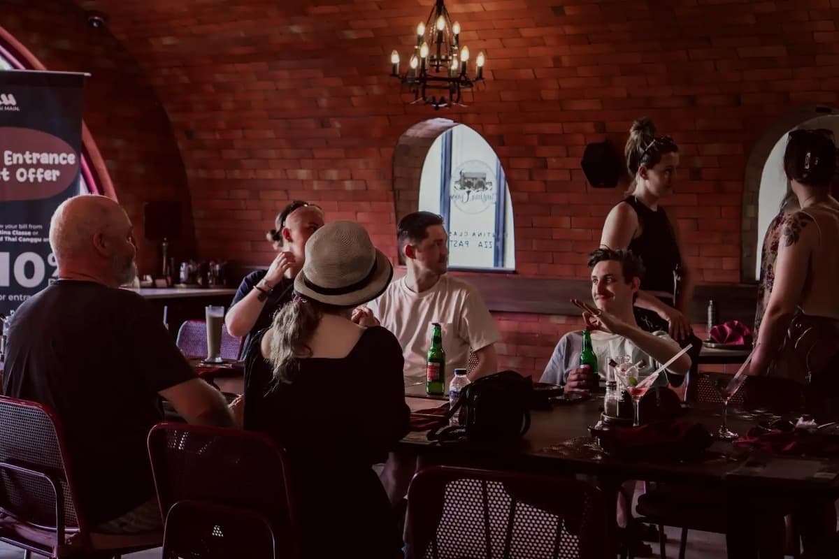 Guests enjoying food and conversation in a Bali restaurant with a relaxed dining atmosphere and shared experience.