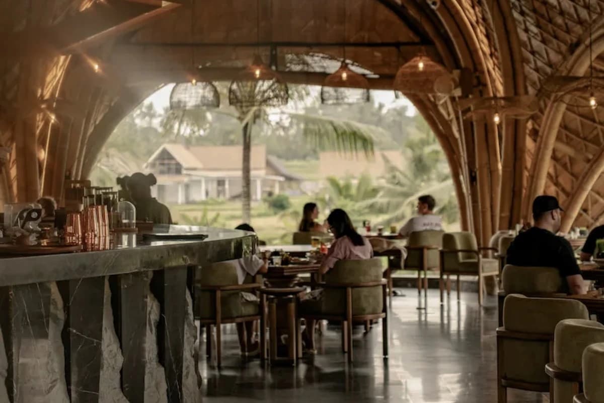 A fine dining restaurant in Ubud with elegant seating, warm lighting, and views of tropical greenery.