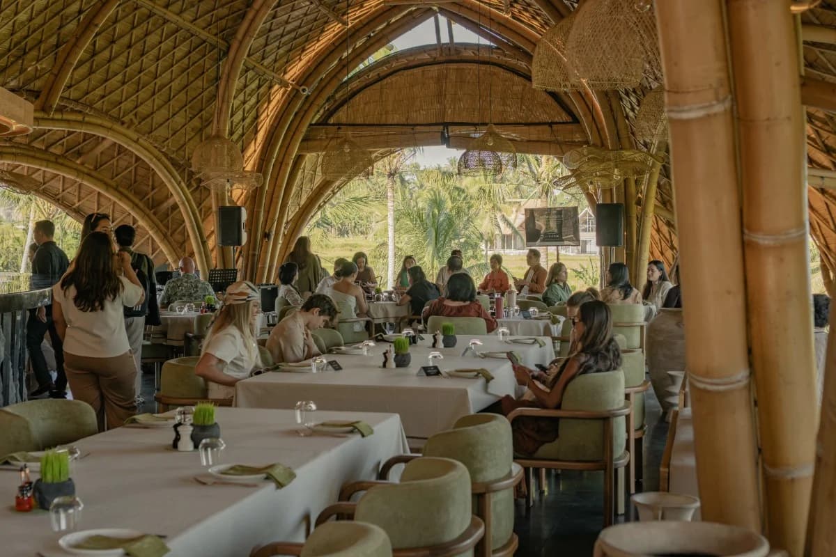 Guests dine together inside a spacious bamboo venue, showing a relaxed private event setting in Ubud.